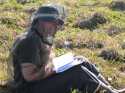 Stephanie Juice, a research assistant records data from inside her protective bug jacket.  Mosquitoes have arrived!